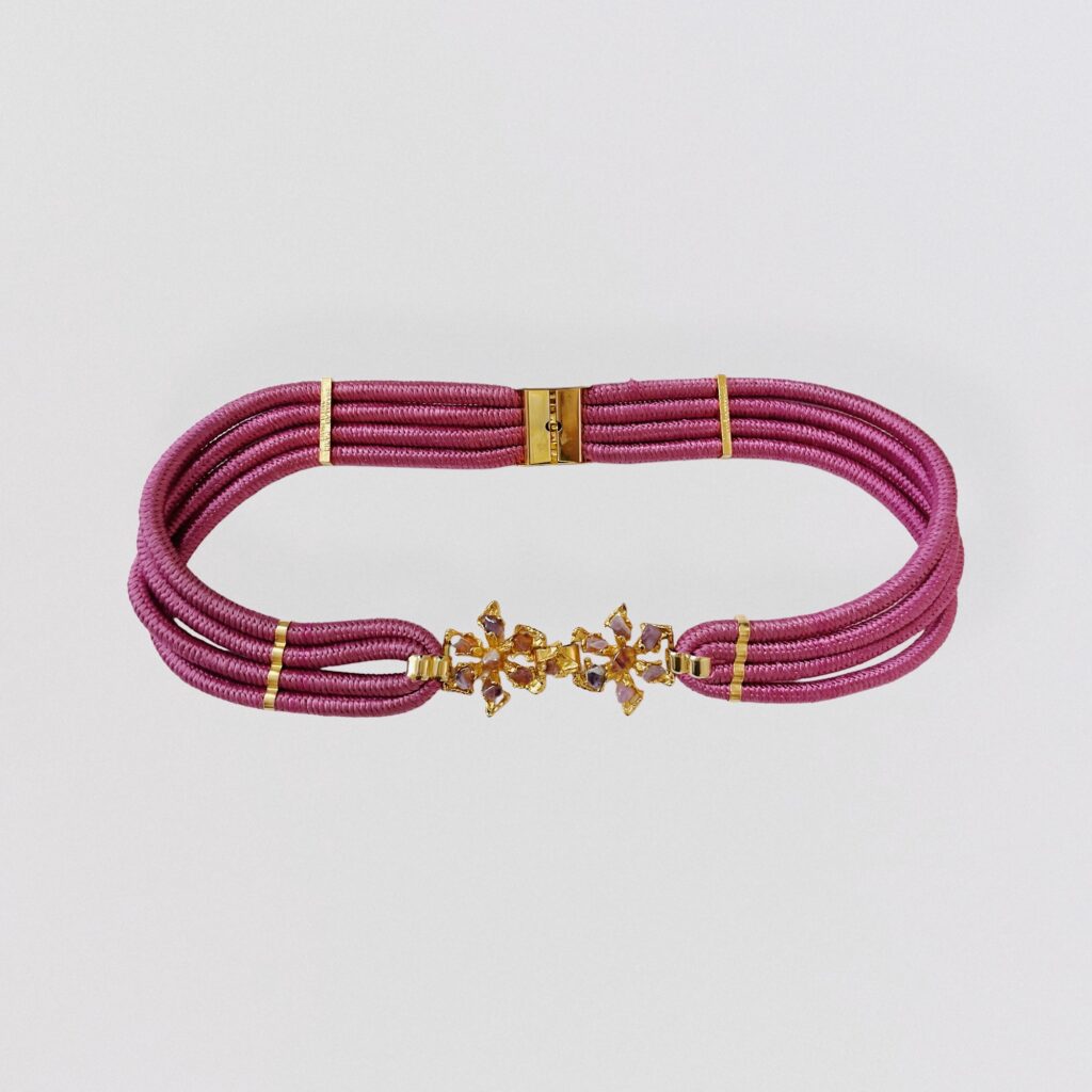 Pink cord belt with gold metal flower clasp set with purple stones